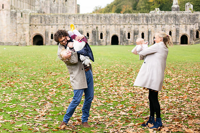 Colour photograph of Mum, Dad with their 6 month old daughter and their 3 year old at Fountains Abbey