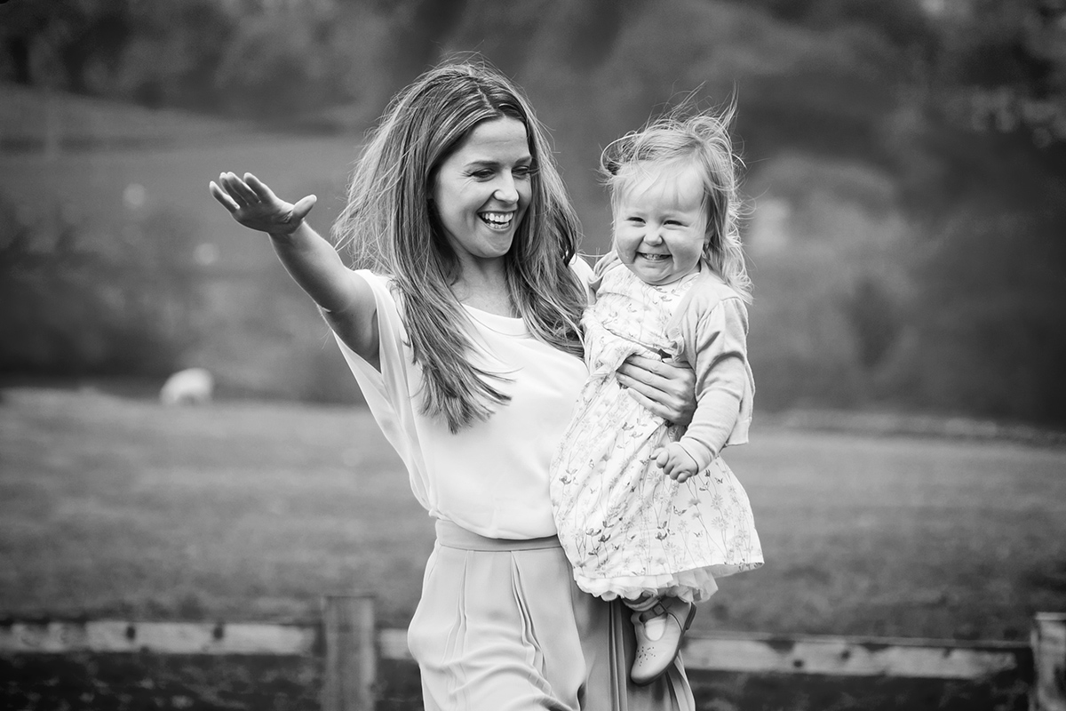 B&W photo of mum and young daughter laughing in the garden in Ilkley