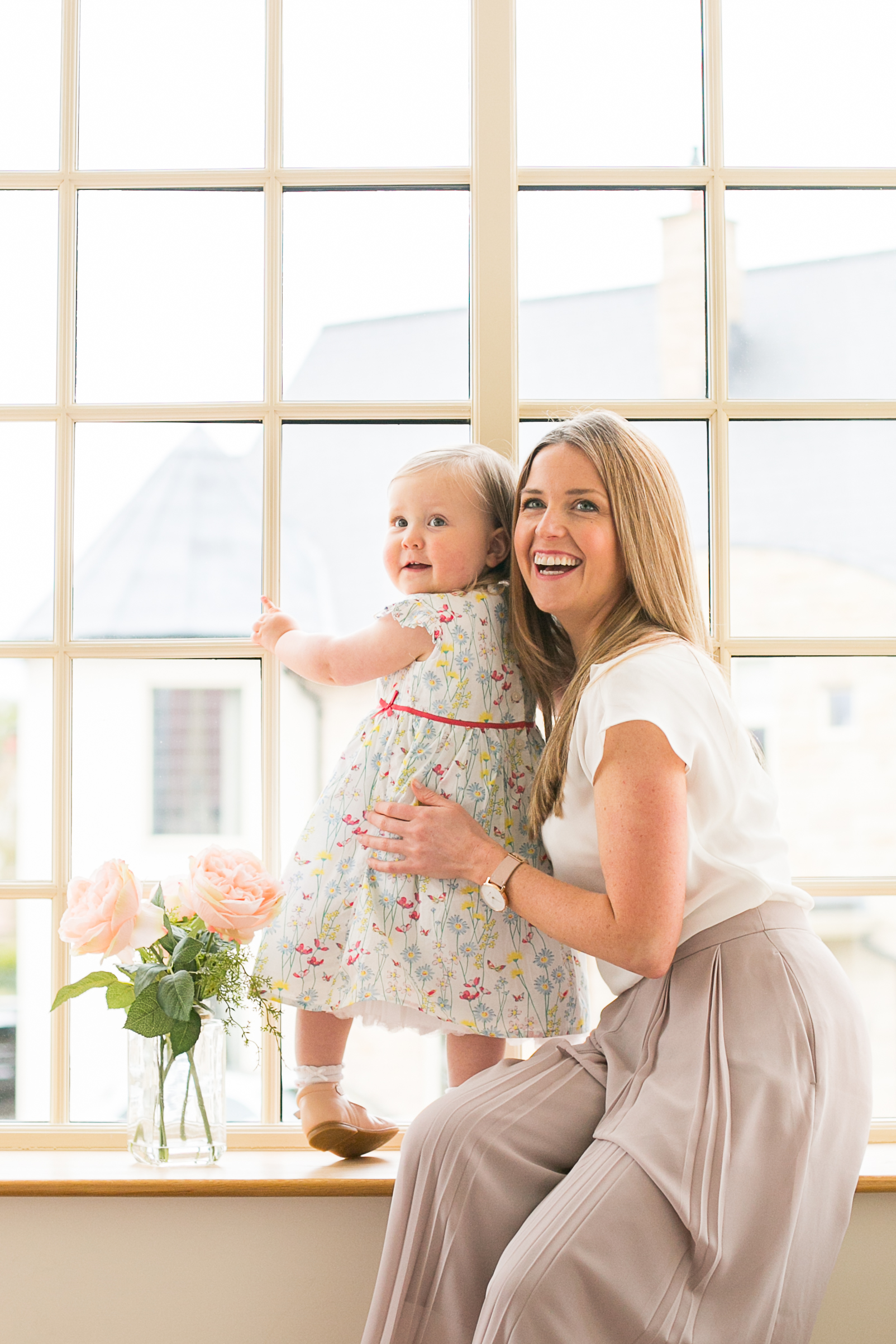 Beautiful colour photo of mum and daughter at a window on an at home photography session