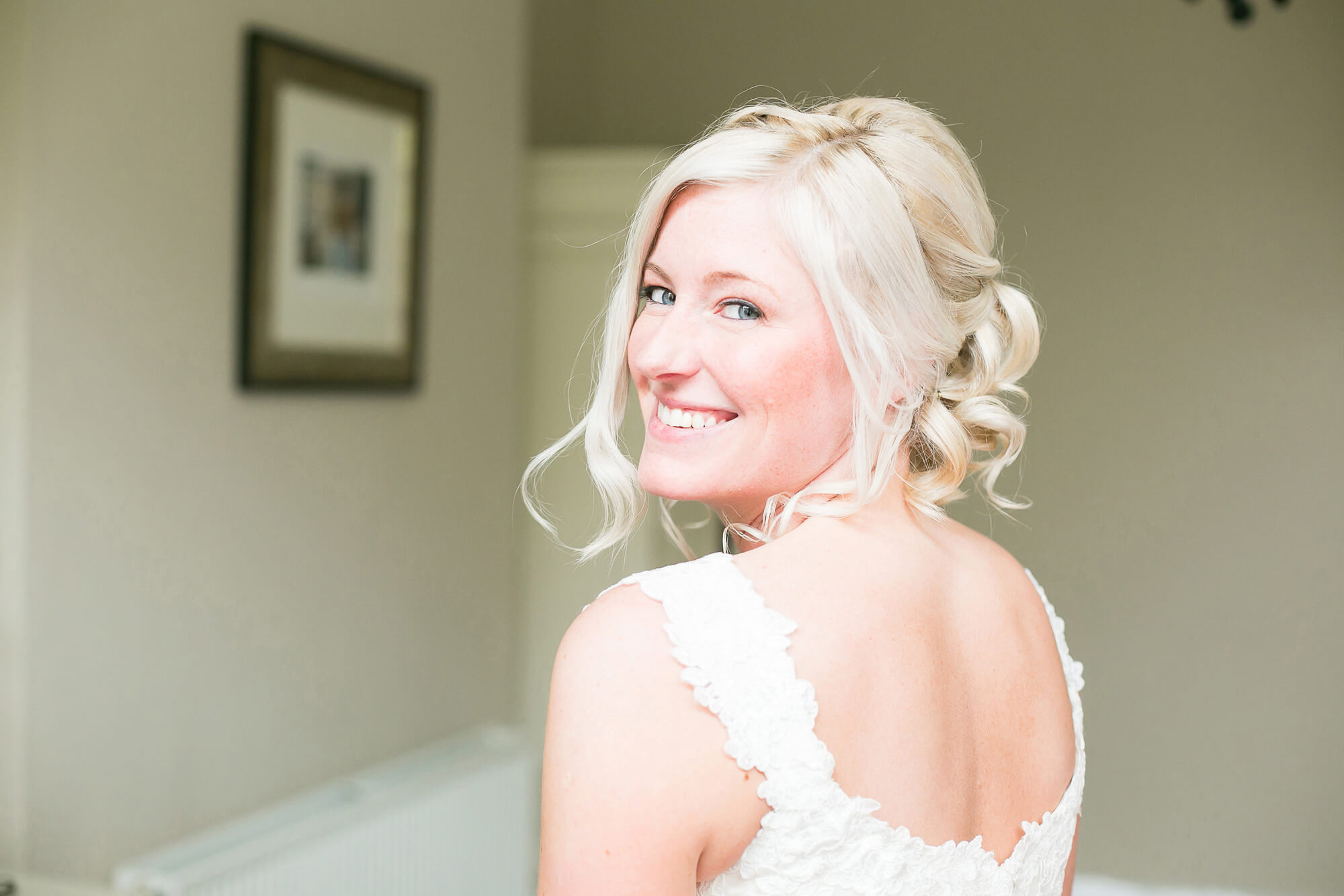 Stunning colour portrait of bride looking over her shoulder as she leaves bedroom on way to church