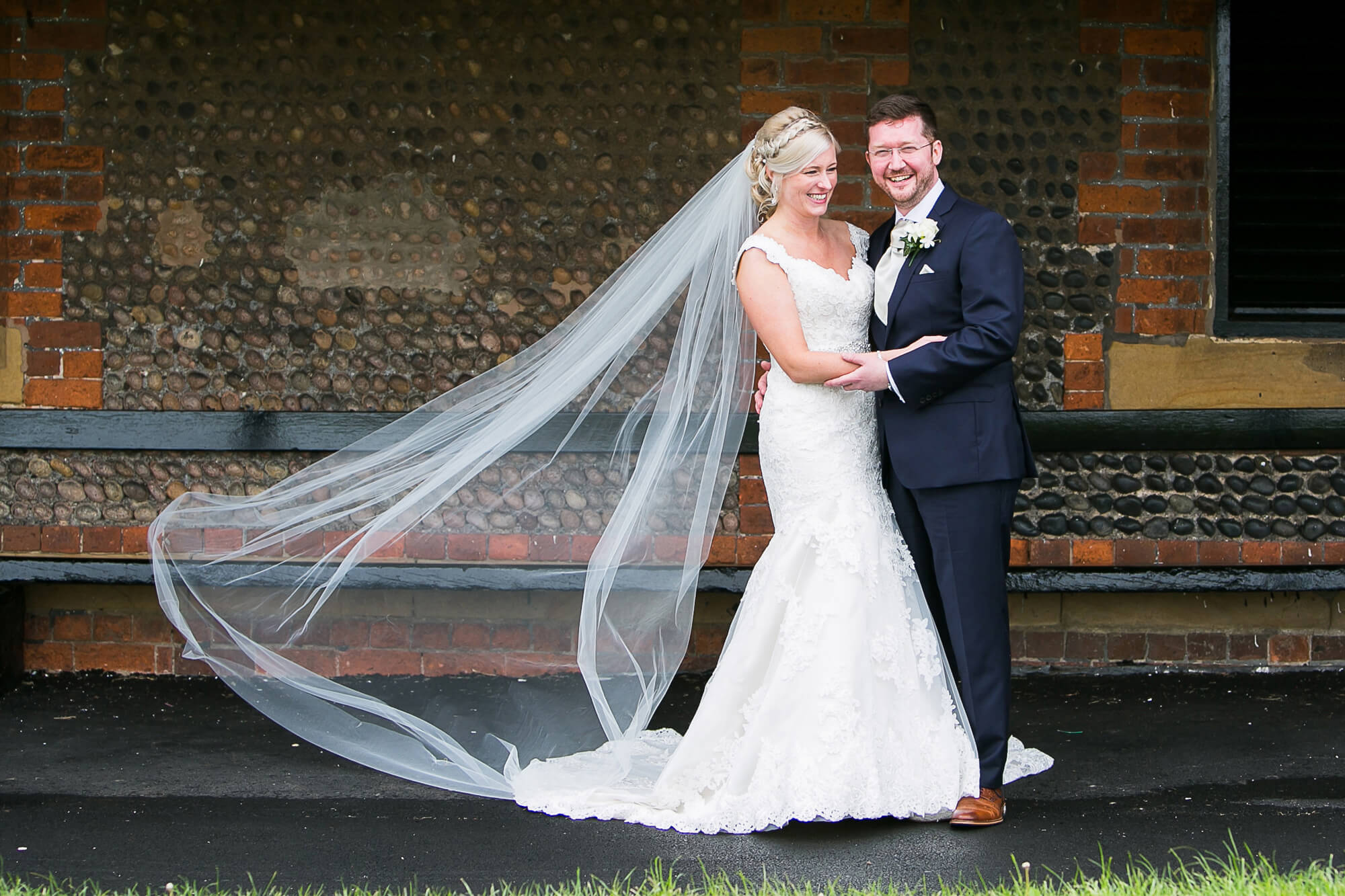 Beautiful colour photo of bride & groom with veil flowing in the wind at windmill Lytham St Annes