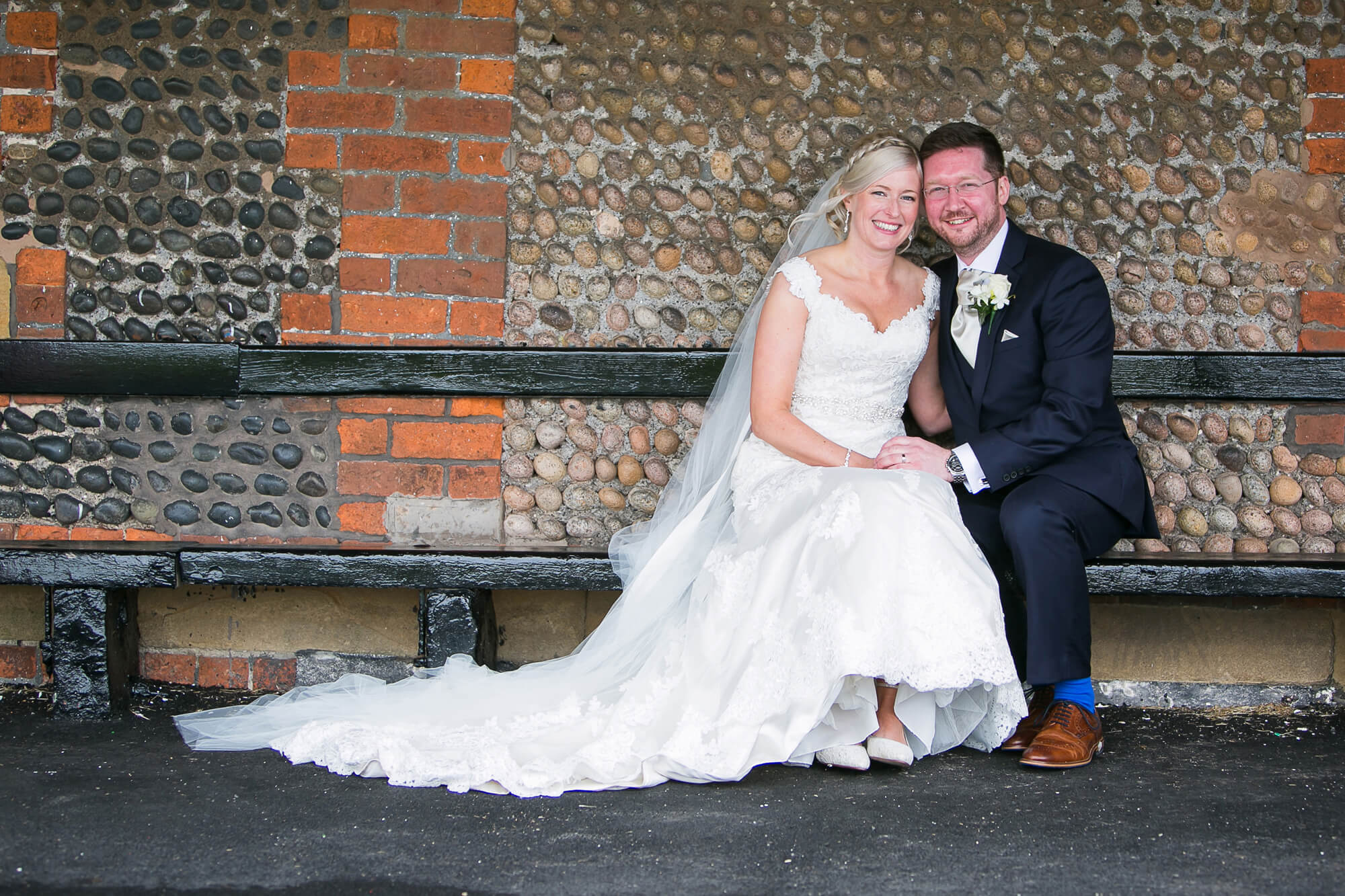 Bride & groom sat on bench at iconic windmill at Lytham St Annes